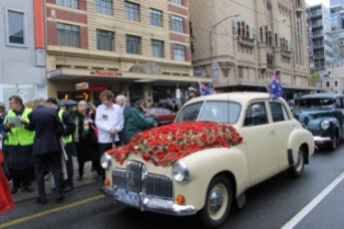 Photo No. 1 of 12 - Anzac Day March at Federation Square, Melbourne, Australia featuring Australia’s first own car – its hood here blanketed with a sheath of poppies photo taken by Karen Robinson 25.4.2015.JPG