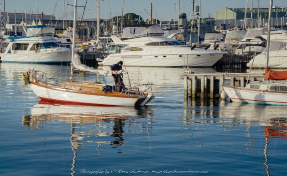 Williamstown, Victoria - Australia 'Views from Ferguson Street Pier' Photographed by ©Karen Robinson June 2022 Comment: Photograph featuring two people motoring their yacht out towards Port Phillip Bay.
